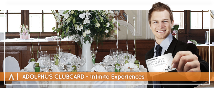 man smiling holding an adolphus club card